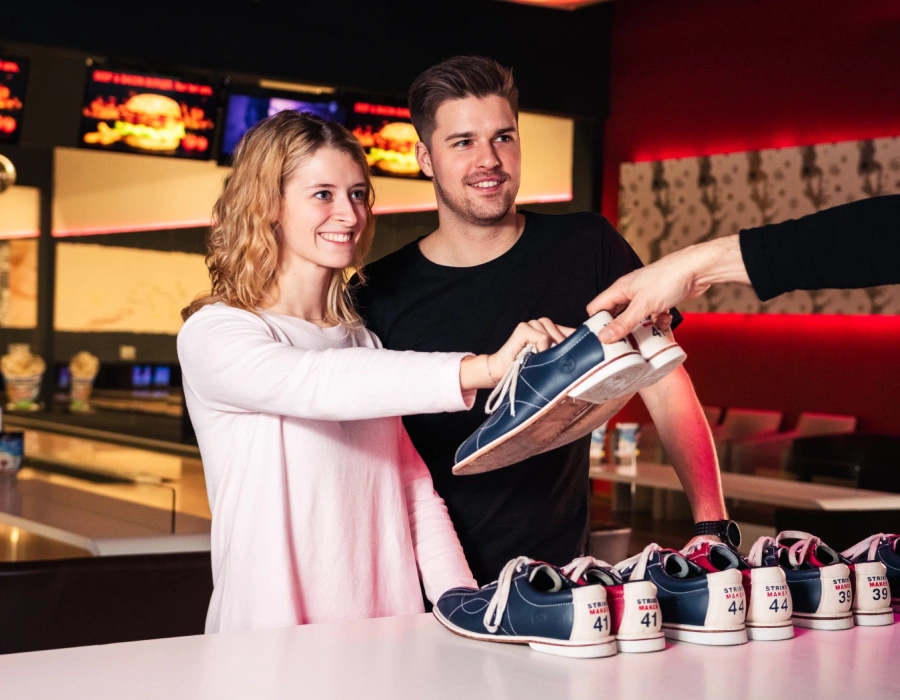 Zwei Jugendliche borgen sich Bowling Schuhe aus